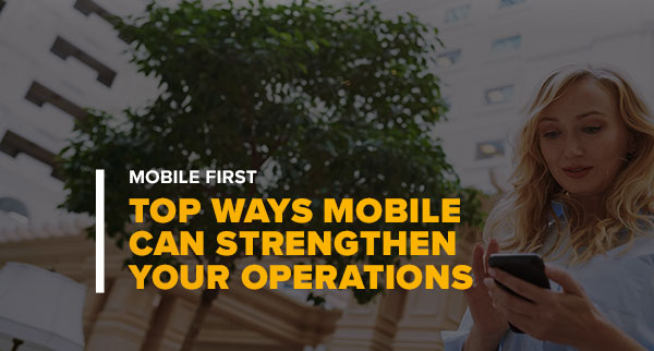 Hotel Worker Checking Phone With Text: Mobile First: Top Ways Mobile Can Strengthen Your Operations