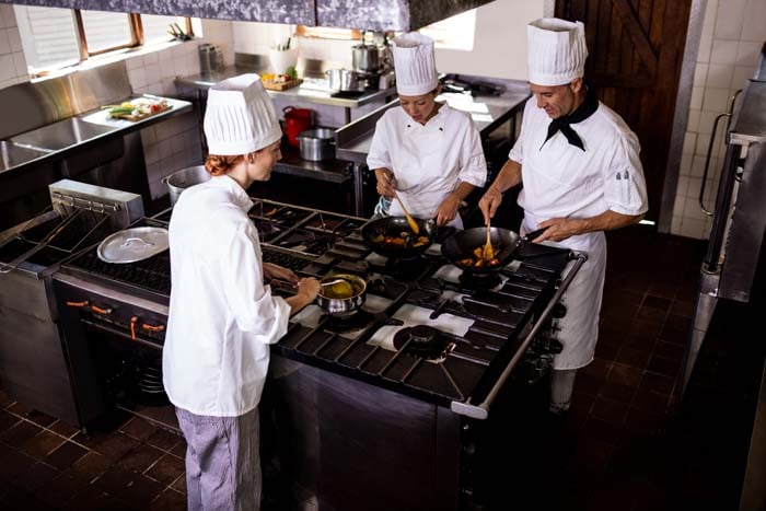 Gruppe von Köchen, die in der Hotelküche Essen zubereiten MB8NGKU